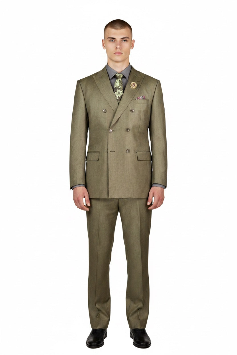 A man modeling a double-breasted olive green suit with a patterned shirt, tie, and pocket square, standing against a solid white background.