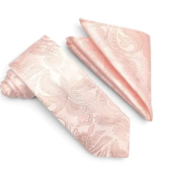 A light pink necktie and matching pocket square set with a subtle paisley pattern, displayed on a clean white background.
