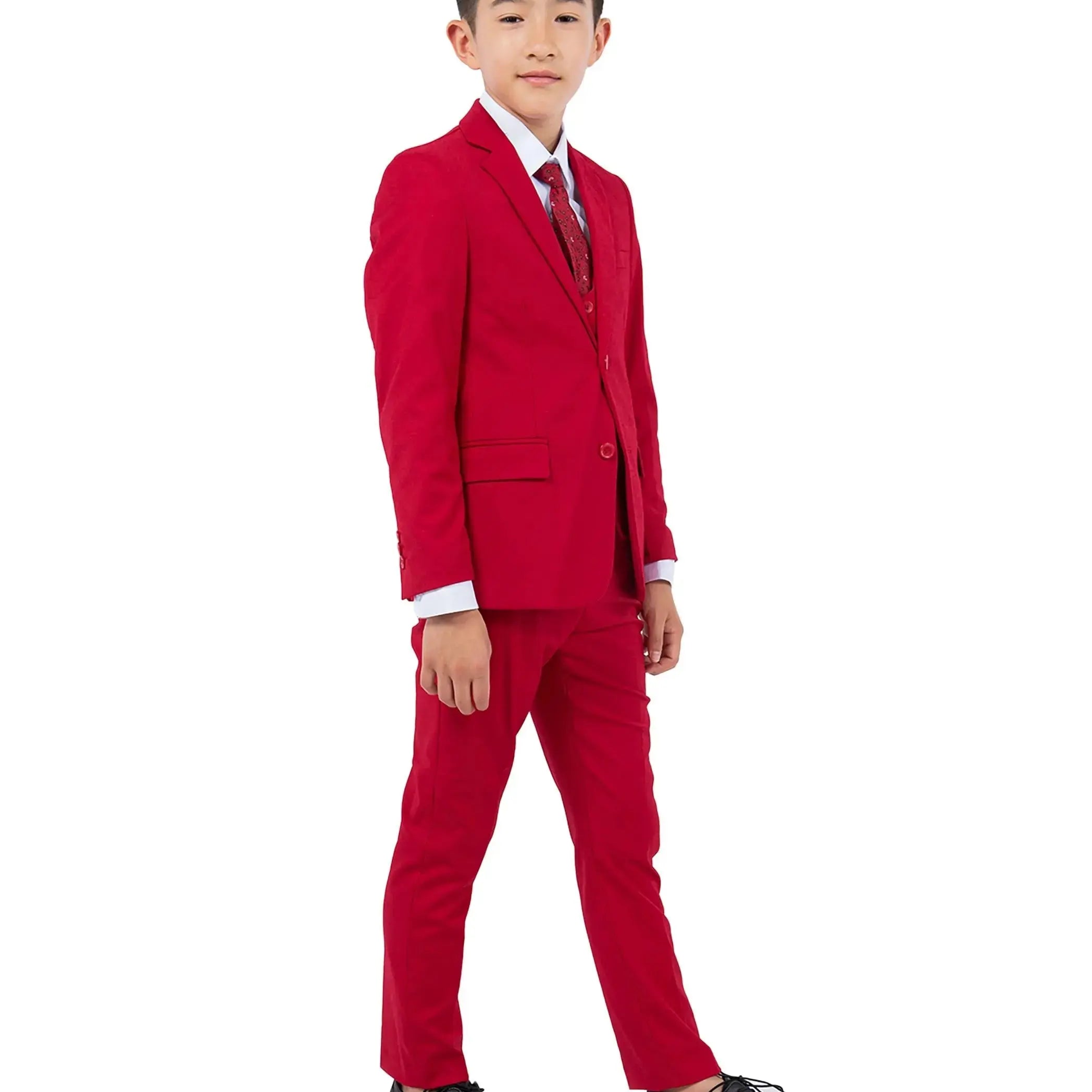 Young boy wearing a red suit with a white shirt and black shoes on a white background