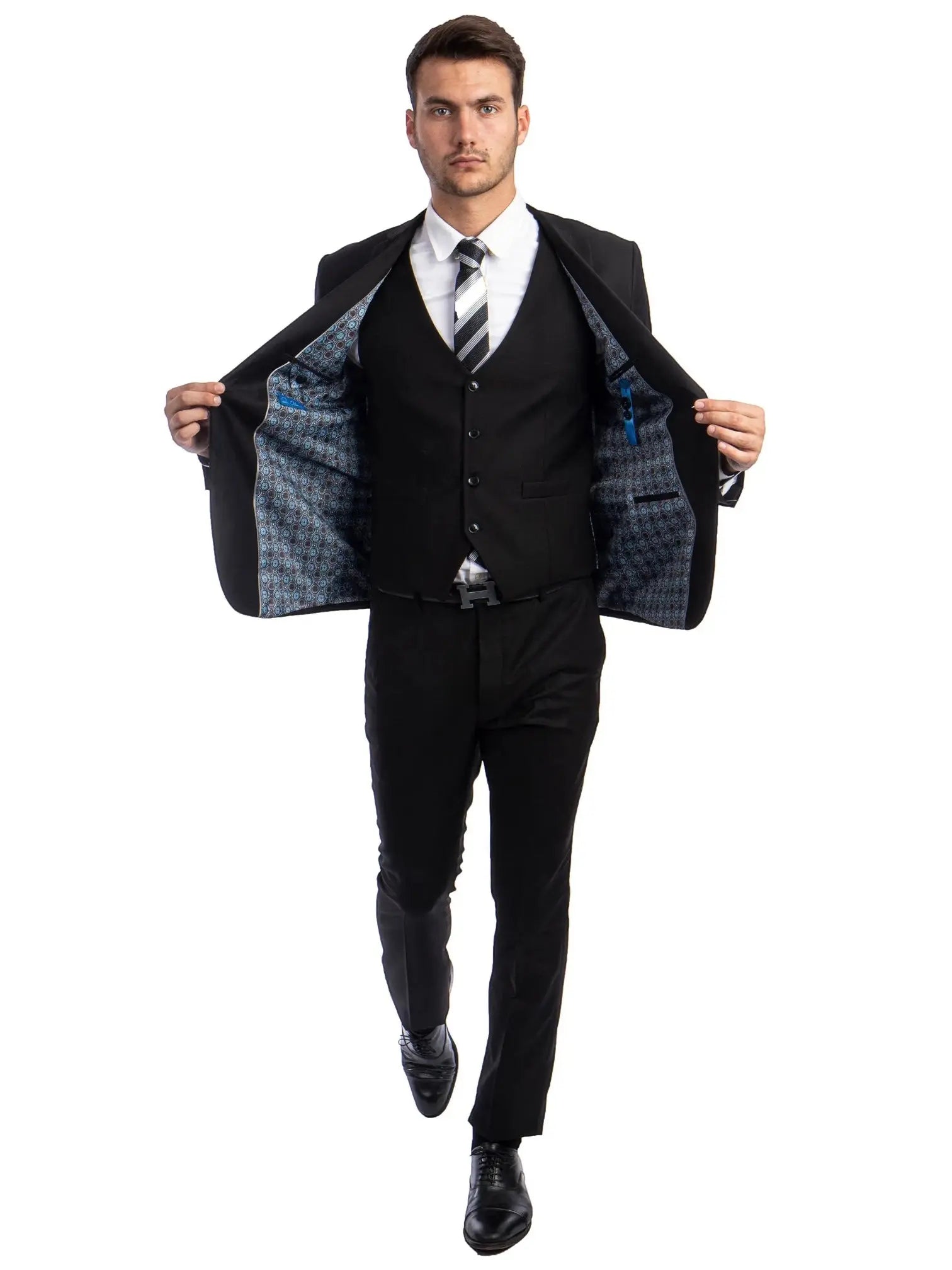 Model wearing a M & R Clothing black skinny-fit 3-piece suit with a patterned interior lining and white dress shirt.