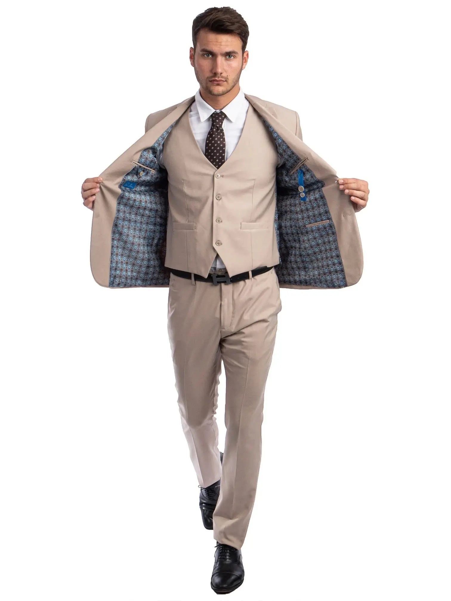 A man wearing a beige M & R Clothing skinny-fit 3-piece suit with a patterned interior lining, white shirt, and tie.