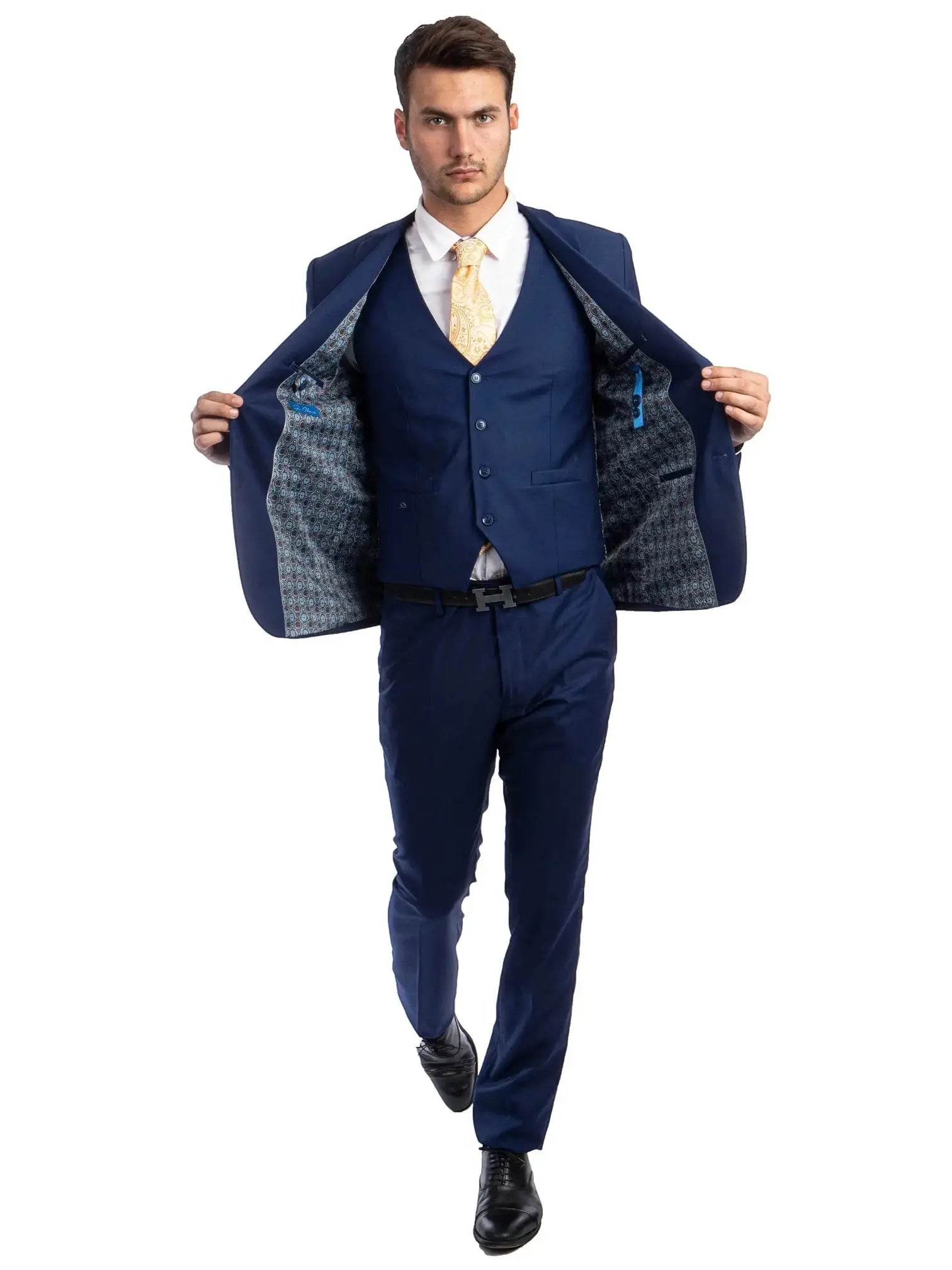 Model wearing a M & R Clothing navy blue 3-piece skinny-fit suit with a patterned lining and yellow patterned tie.
