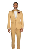 A man modeling a light tan or sandy-colored two-piece tuxedo with satin peak lapels, a matching tie, and a burgundy boutonniere on a white background.