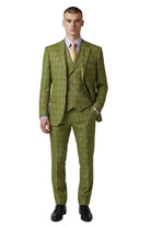 A man modeling a three-piece olive green windowpane plaid suit with a matching vest and trousers, styled with a light purple dress shirt, yellow tie, and silver chain watch, on a light gray background.