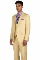 A man modeling a light yellow three-piece suit with a matching vest and trousers, styled with a lavender dress shirt, a purple patterned tie, and a matching pocket square, against a plain white background.