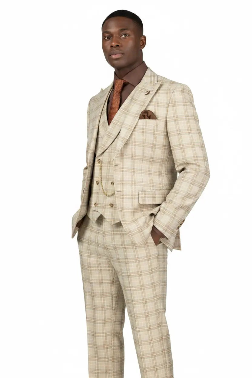 A man modeling a beige and brown plaid three-piece suit, including a jacket, vest, and trousers, paired with a brown shirt and orange-brown tie against a plain white background.