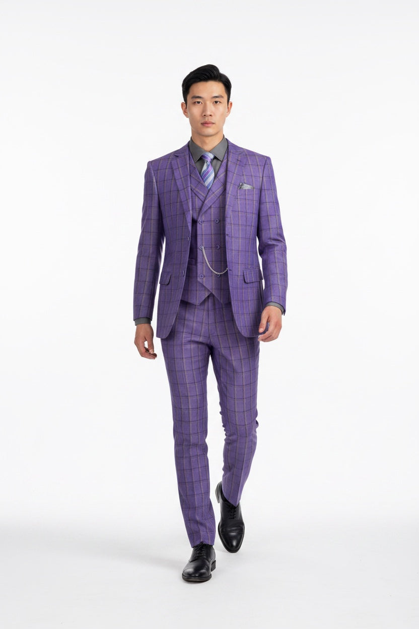 A man modeling a purple and gray checkered three-piece suit with a matching vest and trousers, a light gray dress shirt, a patterned tie, and black dress shoes, set against a plain white studio background.