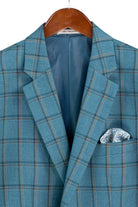 A blue plaid blazer jacket with a patterned pocket square, hanging on a wooden hanger against a white background.