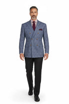 A man modeling a blue and gray double-breasted plaid suit jacket with gold buttons, paired with black trousers, a burgundy tie, and a matching pocket square, on a white background.