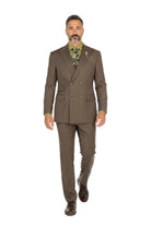 A man wearing a brown double-breasted pinstripe suit with a green patterned shirt and tie, walking forward against a plain white studio background.