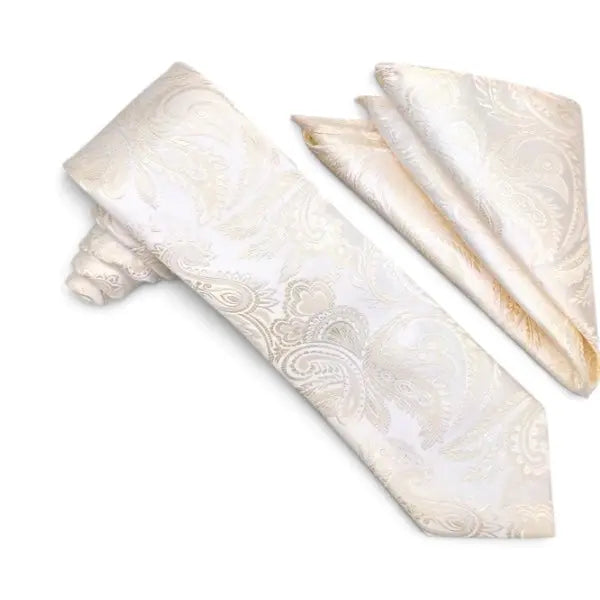 An ivory and cream paisley patterned necktie with a matching pocket square, displayed on a clean white background.