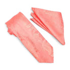 A coral pink necktie and matching pocket square set with a subtle paisley pattern, displayed on a clean white background.