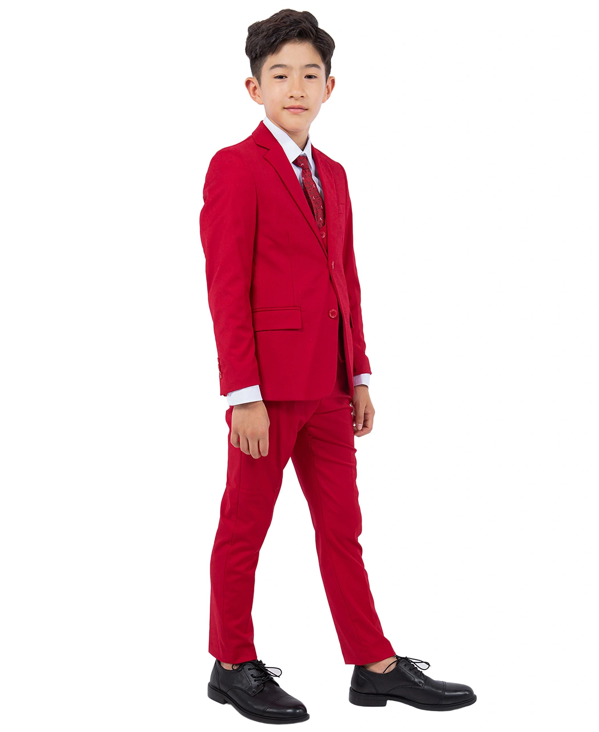 Young boy wearing a red suit with a white shirt and black shoes on a white background