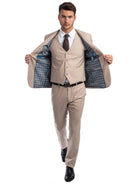 A man wearing a beige M & R Clothing skinny-fit 3-piece suit with a patterned interior lining, white shirt, and tie.