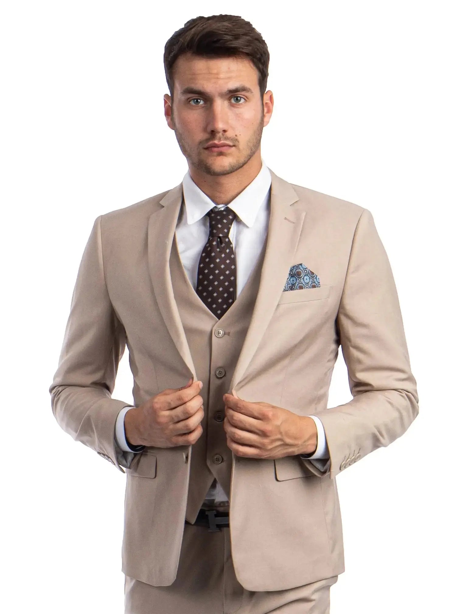 A man wearing a beige M & R Clothing skinny-fit 3-piece suit with a white shirt, brown patterned tie, and pocket square.