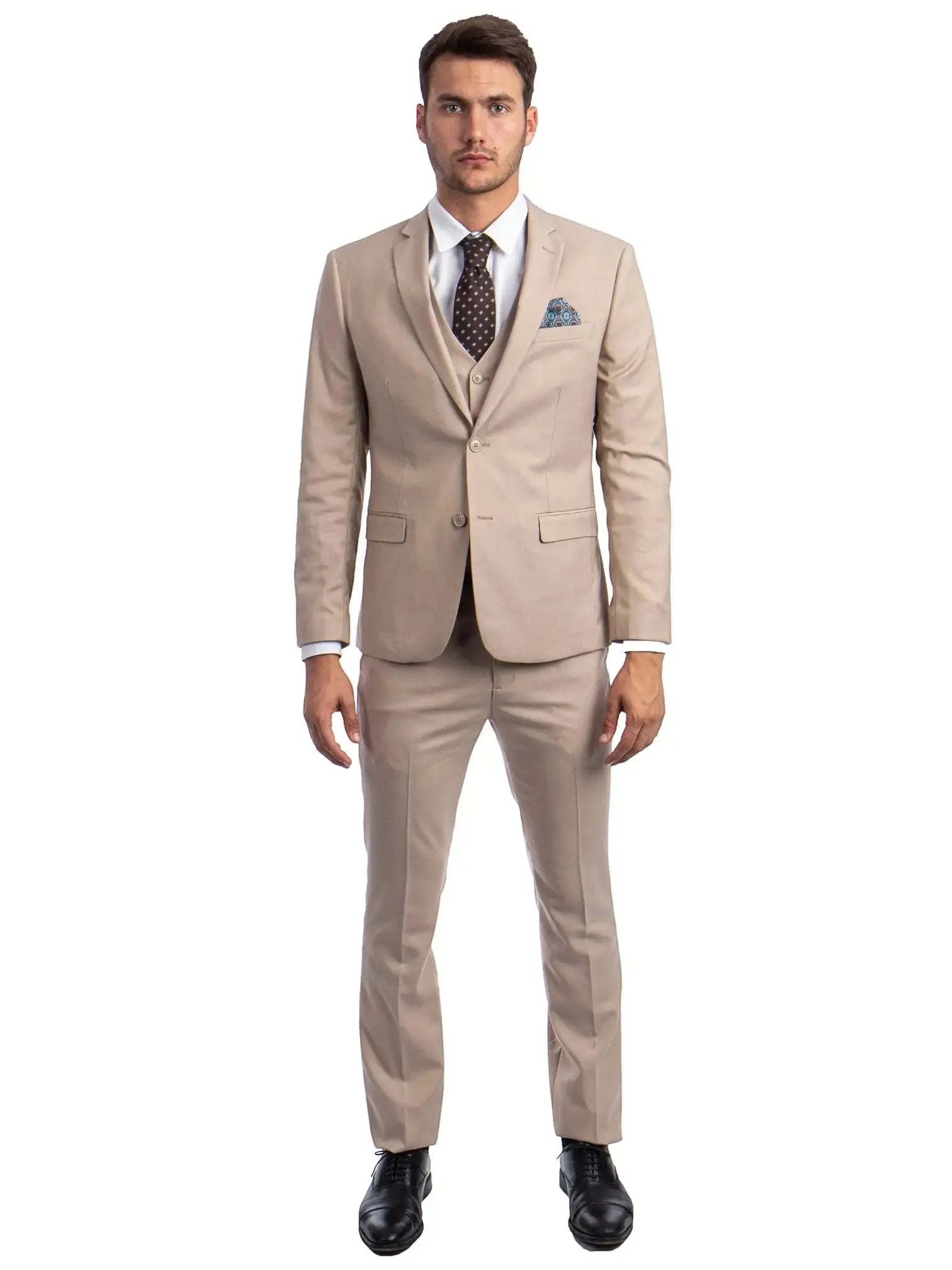 A model wearing a M & R Clothing beige skinny-fit 3-piece suit with a white shirt, polka-dot tie, and black shoes.