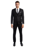 A man wearing a M & R Clothing black skinny-fit 3-piece suit with a white shirt and striped tie against a white background