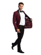 A model wearing an M & R Clothing burgundy tuxedo with a black satin shawl collar, white shirt, and black trousers.