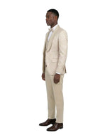 Model wearing a M & R Clothing champagne jacquard 3-piece tuxedo with a satin shawl collar and matching bowtie