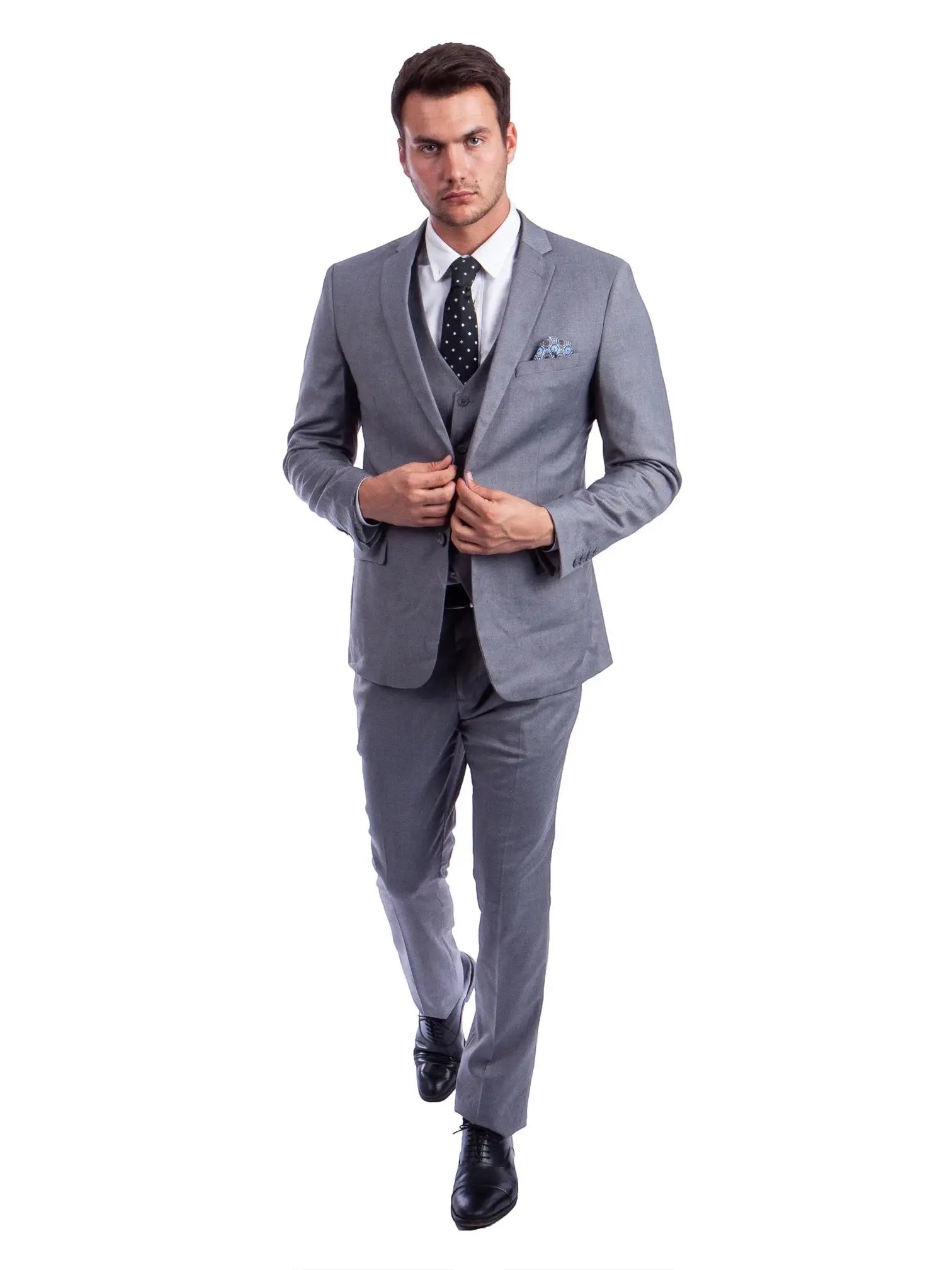 Model wearing a M & R Clothing grey skinny-fit 3-piece suit with a white shirt, black polka dot tie, and dress shoes.