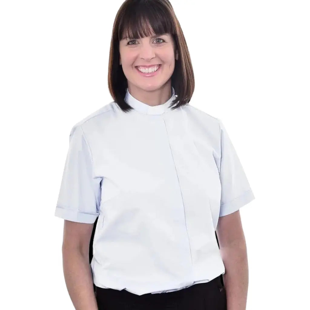 A woman wearing a light blue M & R Clothing short sleeve clergy shirt with a classic tab collar.