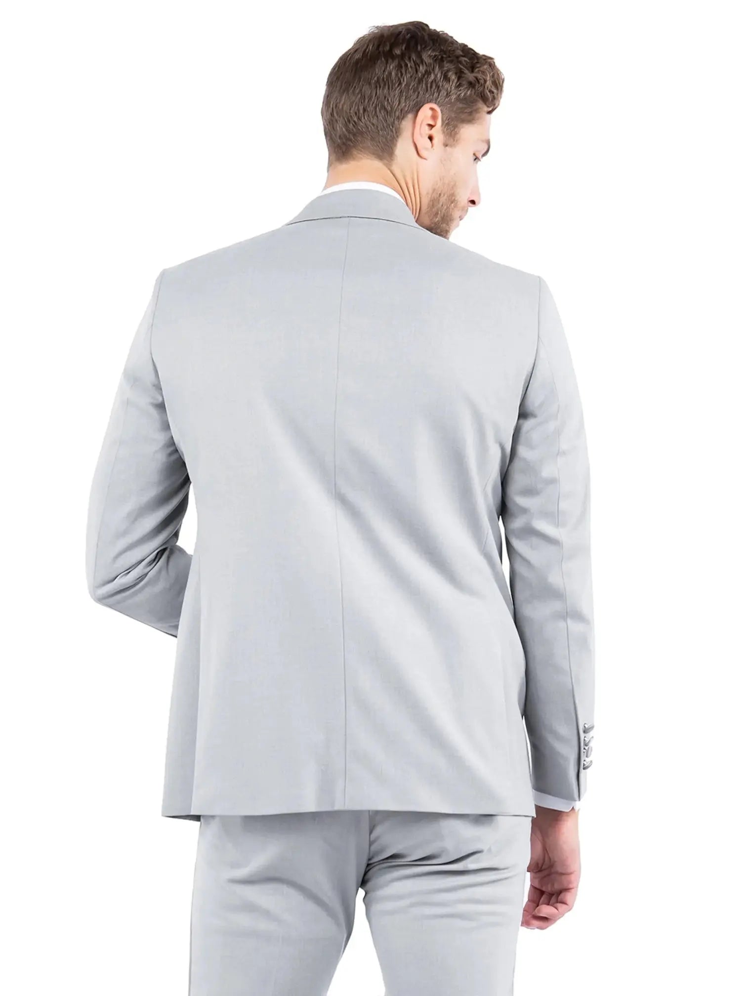 Back view of a man wearing a light grey M & R Clothing tailored-fit tuxedo jacket with a structured silhouette.