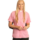 A smiling woman wearing a pink M & R Clothing short sleeve clergy shirt with a classic white tab collar.
