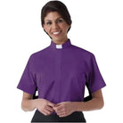 A woman wearing a purple M & R Clothing short sleeve clergy shirt with a white tab collar for ministry.