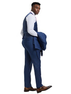 A model wearing a blue M & R Clothing Stacy Adams sharkskin 3-piece suit with a vest and jacket over his shoulder.